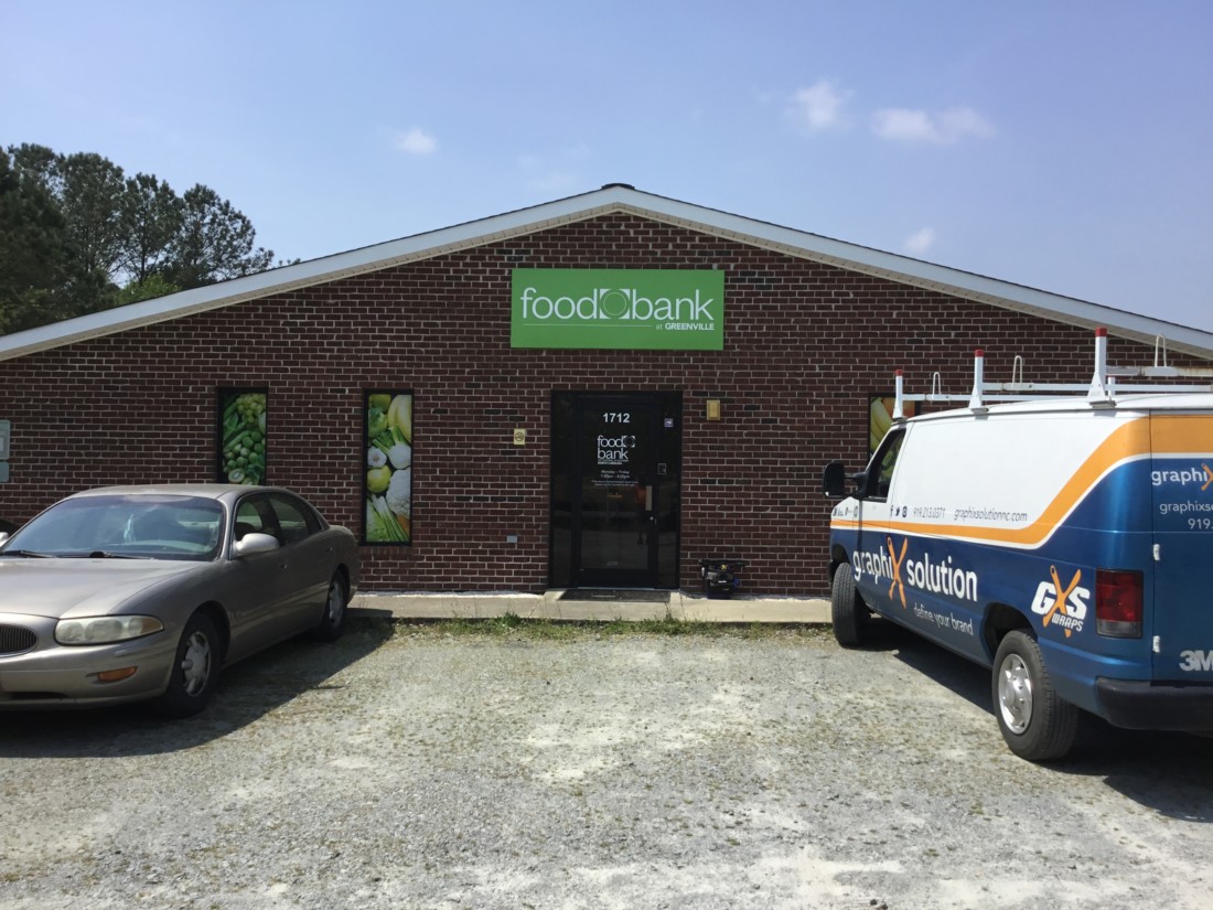 Exterior of Greenville Branch. Red brick building with white and brown sign reading Food Bank of Central & Eastern NC