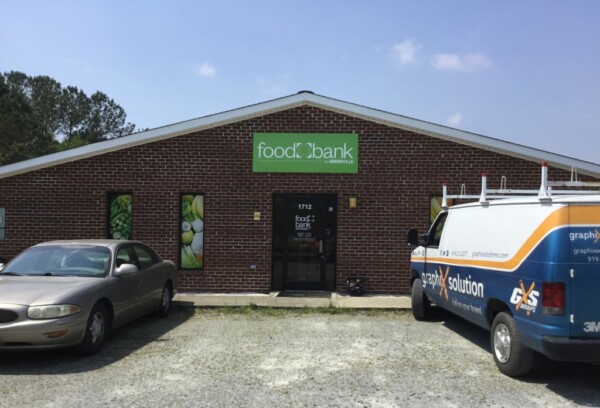 Exterior of Greenville Branch. Red brick building with white and brown sign reading Food Bank of Central & Eastern NC