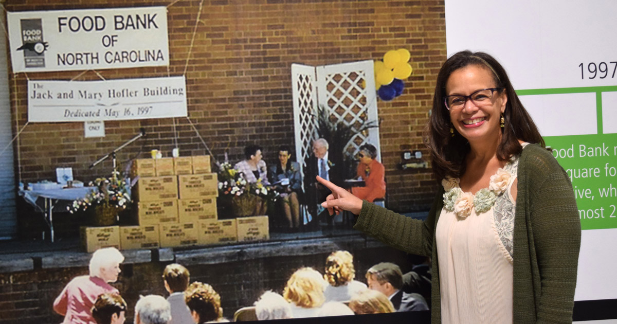 Upon her visit to the Food Bank's new Capital Blvd. facility, Roberta points to herself in a photo from the 1997 grand opening of the Tarheel Drive facility.