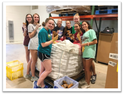 Food Bank Club members at the Food Bank's Raleigh Branch warehouse sorting potatoes into family-sized bags.