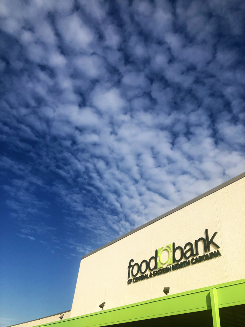 Exterior of Raleigh Branch. White, stone building with bright green portico and black lettering. Food Bank of Central & Eastern North Carolina