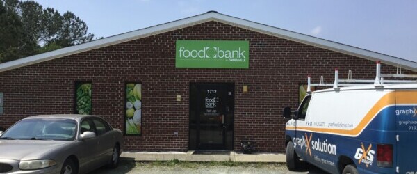 Exterior of Greenville Branch. Red brick building with white and brown sign reading Food Bank of Central & Eastern NC